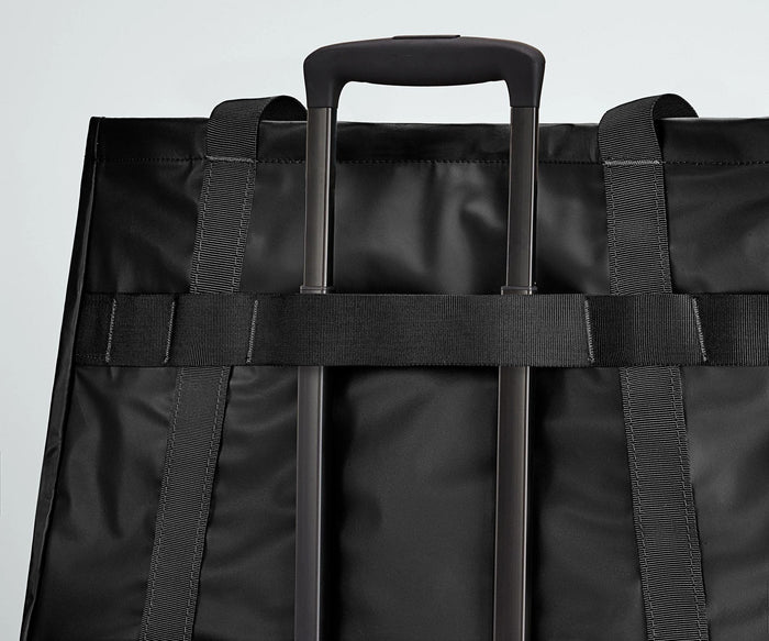 Active Tote 45L secured to an Away suitcase by its trolley strap
