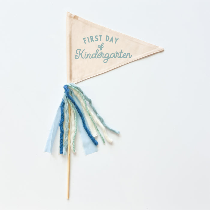 A collection of flag trimmings displayed on sticks, with a variety of colors and decorative elements such as ribbons and feathers.