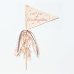 A collection of flag trimmings displayed on sticks, with a variety of colors and decorative elements such as ribbons and feathers.