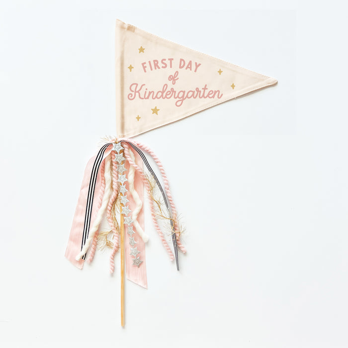 A collection of flag trimmings displayed on sticks, with a variety of colors and decorative elements such as ribbons and feathers.