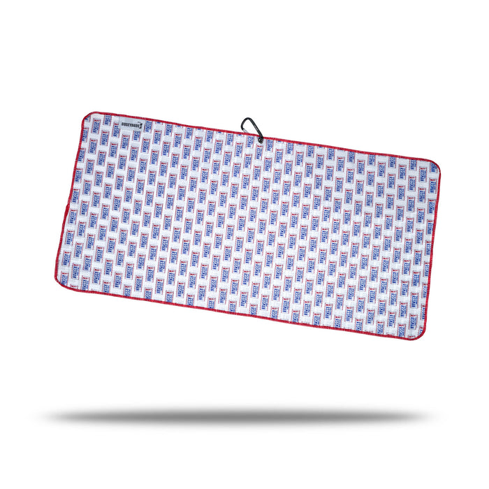 The ASSMAN - Towel is a rectangular microfiber towel with blue and red geometric patterns on white, finished with red trim. It features a black clip, an eyelet hanging loop, and a small label, shown on a white background with shadow.