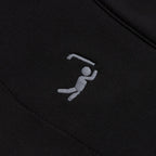 A close-up of the Black - Q-Zip’s moisture-wicking fabric shows an embroidered white stick figure swinging a bent object, suggesting sports action. The stitching and textured fabric are clearly visible.