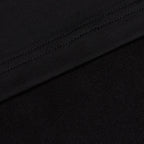 Close-up of Black - Q-Zip showing two black fabrics: the upper section features a stitched seam on smooth, athletic-fit material, while the lower part displays a softer, textured surface. The fabrics meet diagonally across the image.