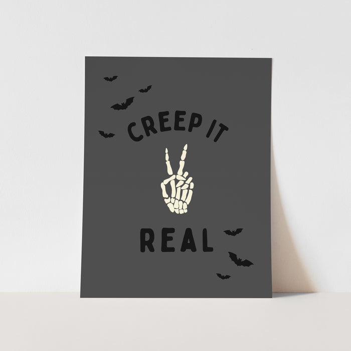 Halloween-themed card with skeleton hand and text on a gray background