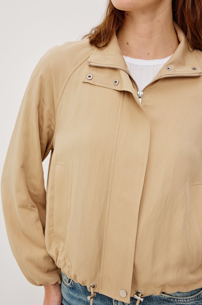 Blake Oversized Cropped Jacket With High Funnel Neck Double-Button Closures Long Drop Shoulder Sleeves With Elastic Cuffs Side Pockets and Drawstring Hem in Almond Colorway - Upper Body Close Up View Featured on Model