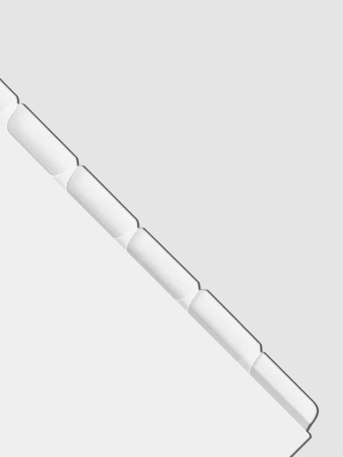 Closeup of blank divider tabs on a neutral background.