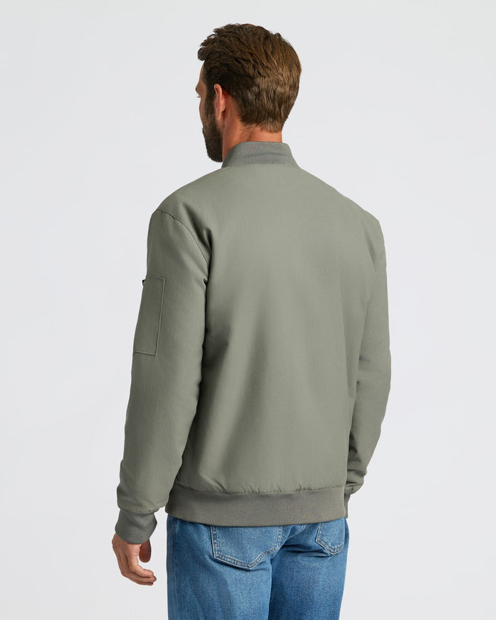 Man wearing Carbon Bomber Jacket with jeans, viewed from behind.
