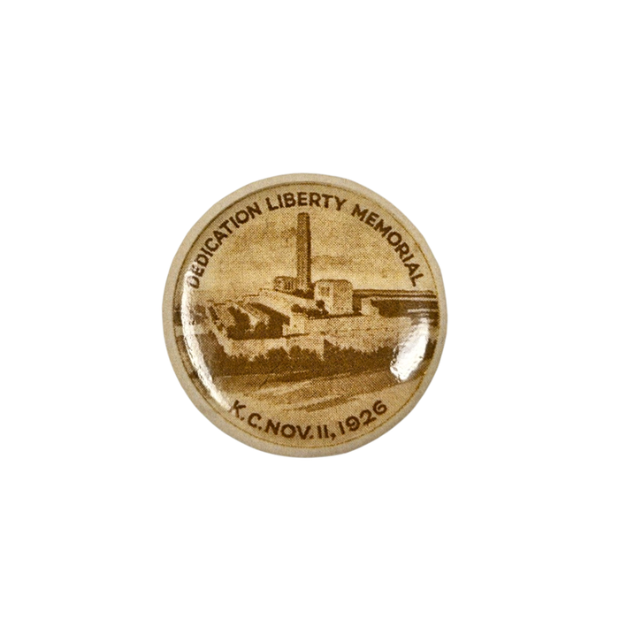 An off yellow button with an illustration of the Liberty Memorial tower from bird's eye view. On the top of the button it reads DEDICATION LIBERTY MEMORIAL and on the bottom it reads K.C.NOV.11,1926.