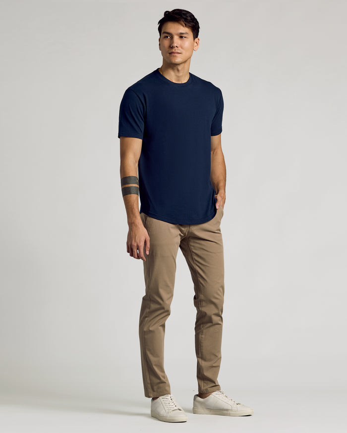 Young man wearing Navy Curved Hem Classic Crew Neck and khaki chinos.