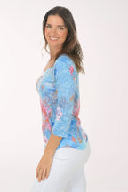 Woman wearing a multicolored 3/4 sleeve top.