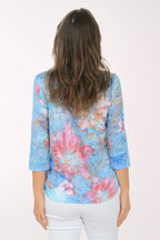 Woman wearing a multicolored 3/4 sleeve top.
