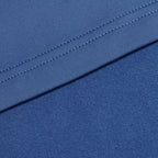 Close-up of two layers of Cooler Blue - Q-Zip fabric; the upper layer features neat edge stitching, while the lower layer is smooth and soft with moisture-wicking properties. Both fabrics overlap diagonally, suggesting contrasting textures.