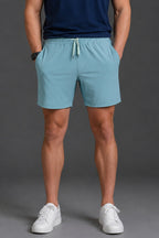 Person wearing light blue shorts and white sneakers on a gray background || Underseas