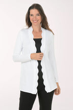Woman wearing a white cardigan over a black top on a white background