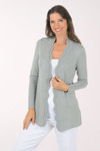 Woman wearing a gray cardigan over a white top on a white background