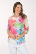 A woman wearing a multicolored tie-dye top.