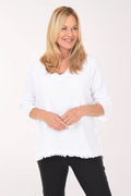 Woman wearing a white sweater and black pants on a white background