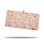 The Glizzy Gobbler - Towel is a rectangular microfiber towel with orange BBQ-themed grills, flames, utensils, and condiments on white. Features double-sided print, orange edging, black hanging loop, red logo tag (bottom right), and shadow below.