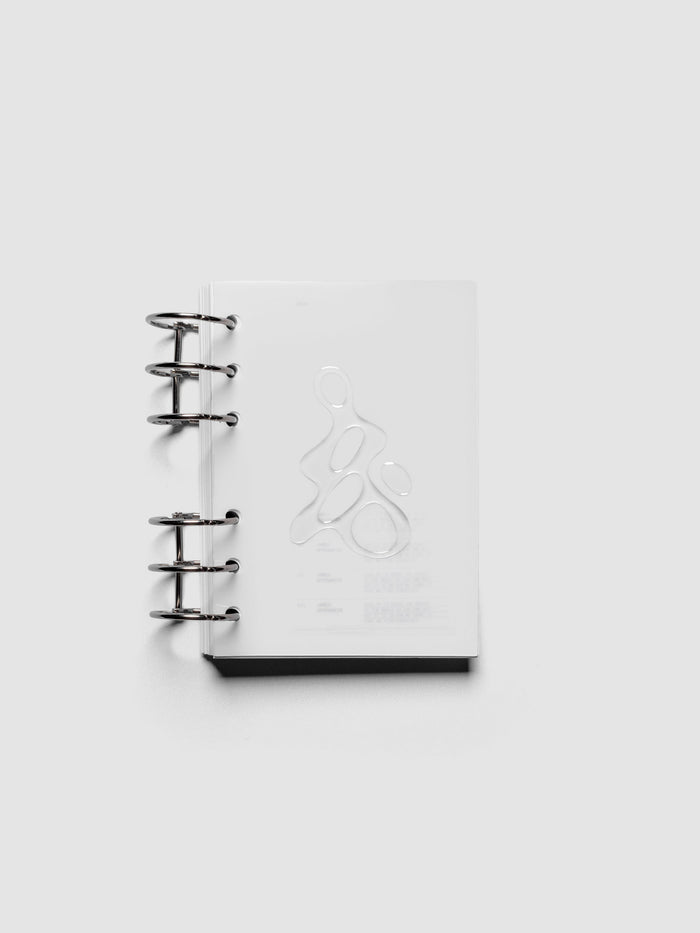 Light grey, semi-transparent, and glossy plastic planner dashboard with organic raised shape design in size A6 shown ringbound.