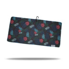 The Haolie Nights - Towel is a rectangular microfiber towel with a dark background, double-sided print of red and blue monstera leaves plus teal palm fronds. It features blue edging, a clip and eyelet loop at the top, and a white tag in the bottom right corner.