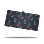 The Haolie Nights - Towel is a rectangular microfiber towel with a dark background, tropical leaf print in green, blue, and red, light blue trim, black clip and eyelet at the top, dual-sided print design, and a subtle shadow beneath.