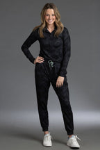 Woman wearing a black outfit with white sneakers on a gray background || Black Camo