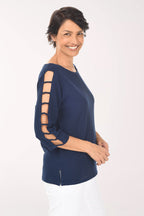 Woman wearing a navy blue top with cut-out sleeves on a white background