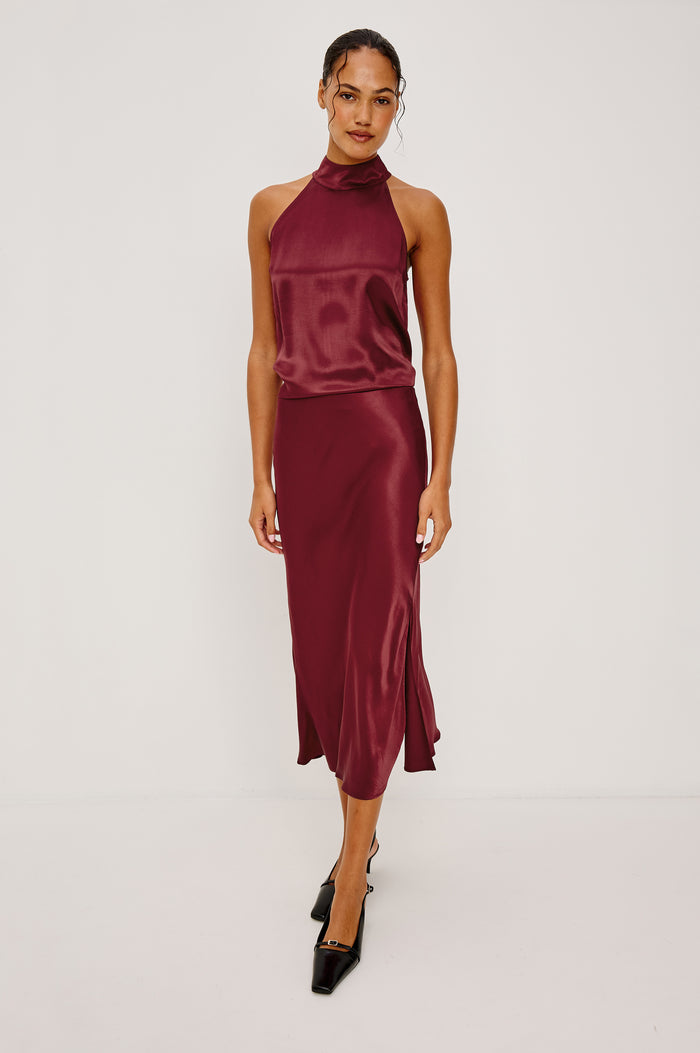 Leah Halter Top in Satin Crepe With a High Neckline, Sleevleless Cut, Back Button Neck Closure in Garnet Colorway - Full Body Front View Featured on Model
