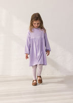 Wearing a purple dress and leopard leggings.
