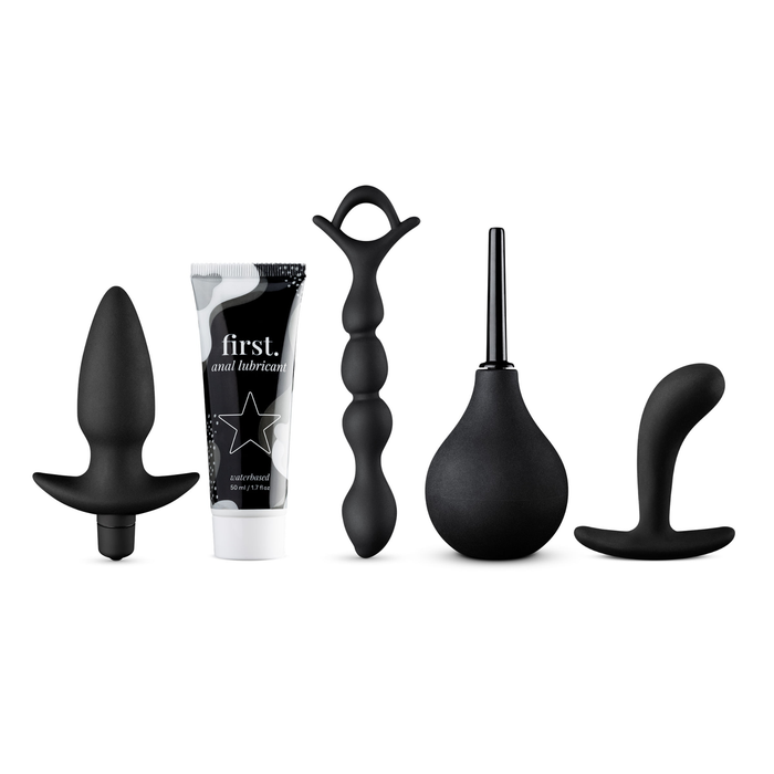 A complete set of five black products for anal play, including two different butt plugs, a beaded anal chain, a rubber douche, and a tube of water-based anal lubricant.