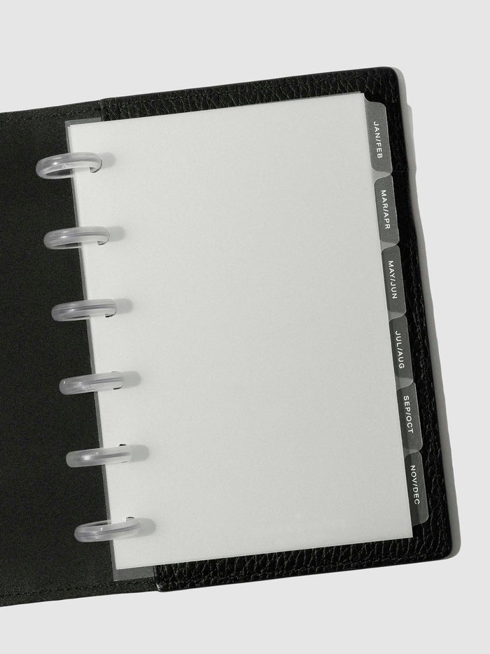 White foil tabs displayed in use inside a black leather folio.