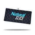 The Natural Slice - Towel is a rectangular black microfiber towel featuring small blue and white geometric patterns, "Natural SLICE" in bold blue and white text, a black hanging loop with clip and eyelet, plus two-sided print.