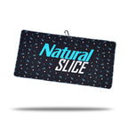 The Natural Slice - Towel is a rectangular black microfiber towel featuring small blue and white geometric patterns, "Natural SLICE" in bold blue and white text, a black hanging loop with clip and eyelet, plus two-sided print.