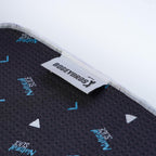 Close-up of the Natural Slice - Towel, a black microfiber towel with textured surface, blue and white text and triangle patterns. It features a white fabric tag with the black BOGEYBRO$ logo on the edge and 2-sided print.