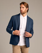 Man models Navy Comfort Knit Blazer with white shirt and tan chinos.