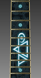 up close image of a fret protector that is black with dark colored symbols throughout. descending from the center of the fret protector is a glowing light blue and white steve vai logo.  The steve vai logo makes the word "vai" with an upside down triangle, a right side up one, and a line going across the triangles with a curl at the end next to the triangle that is upright.