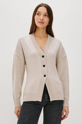 Longline cardigan in a cotton-wool blend in Taupe Colorway. The design features drop shoulders and a front cutaway detail, creating a soft, relaxed, and flattering silhouette. Front View on Model.