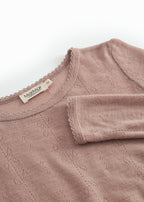 Detalje: rosa uld pointelle-T-shirt med rund hals og mærke i nakken.