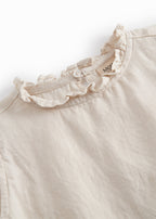 Sleeveless beige top for children with pleats.
