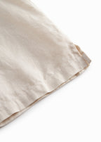 Sleeveless beige top for children with pleats.