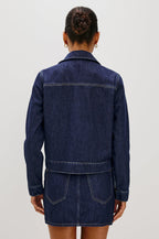 The Trabuco is a collared two-way zip front jacket with two chest pockets and a western style yoke in Deep Indigo colorway - a rinse denim wash. Back view featured on model.