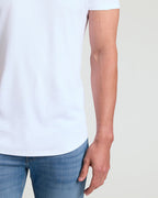 Close-up of a man wearing a white Tall Pima Cotton Blend Curved Hem Crew 7-Pack shirt paired with blue jeans, showcasing the curved hem detail and smooth cotton blend fabric.